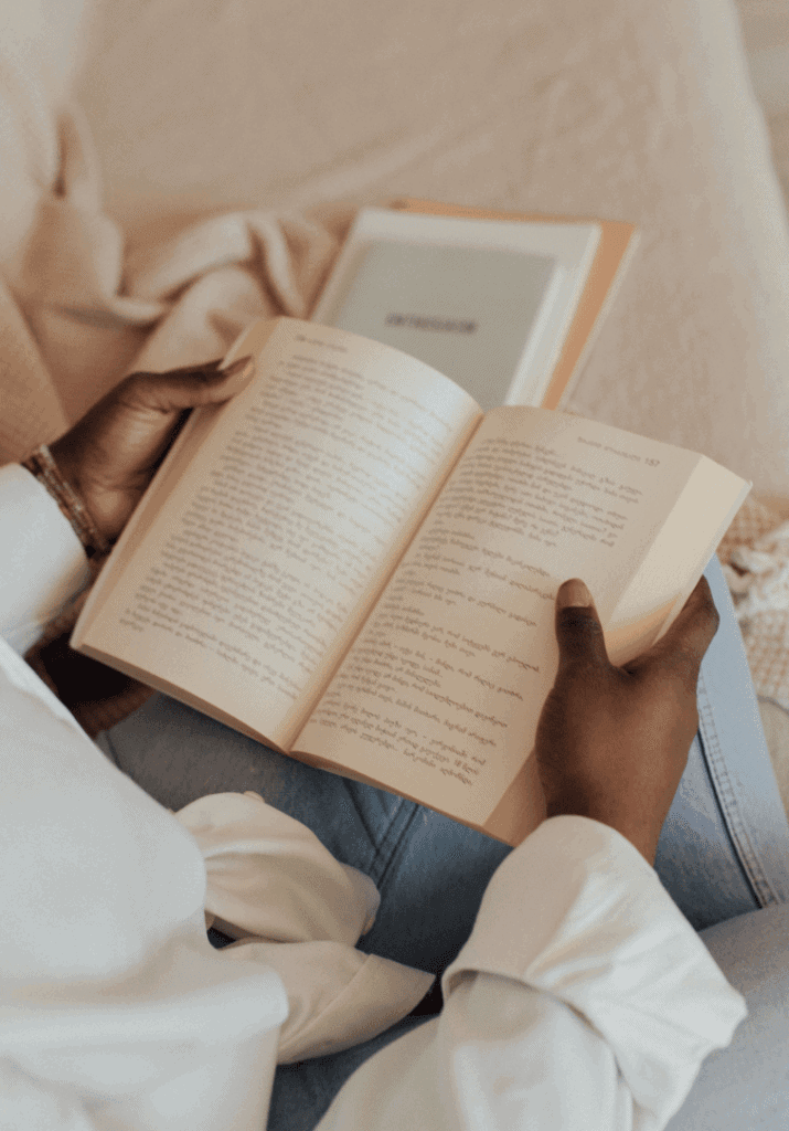 A woman in a cozy reading nook enjoying her book 