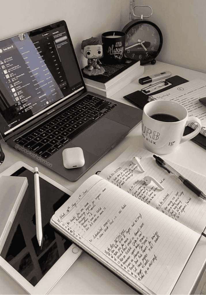 A desk with a laptop, notebook and coffee cup highlighting How to pursue your dreams successfully