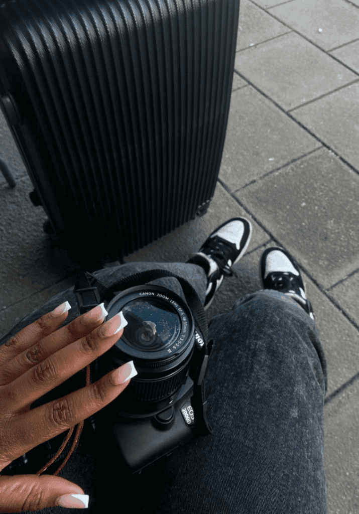 Woman holding her camera in her can highlighting pursing her dreams