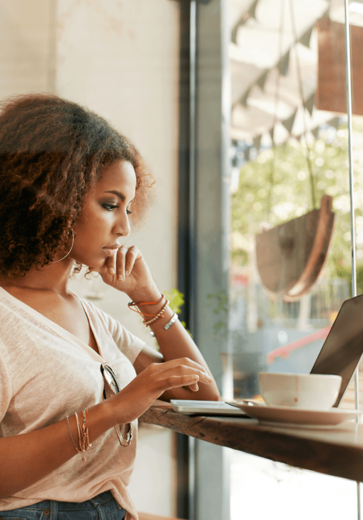 a black woman being productive and looking at her computer showing how how hobbies boost self-esteem