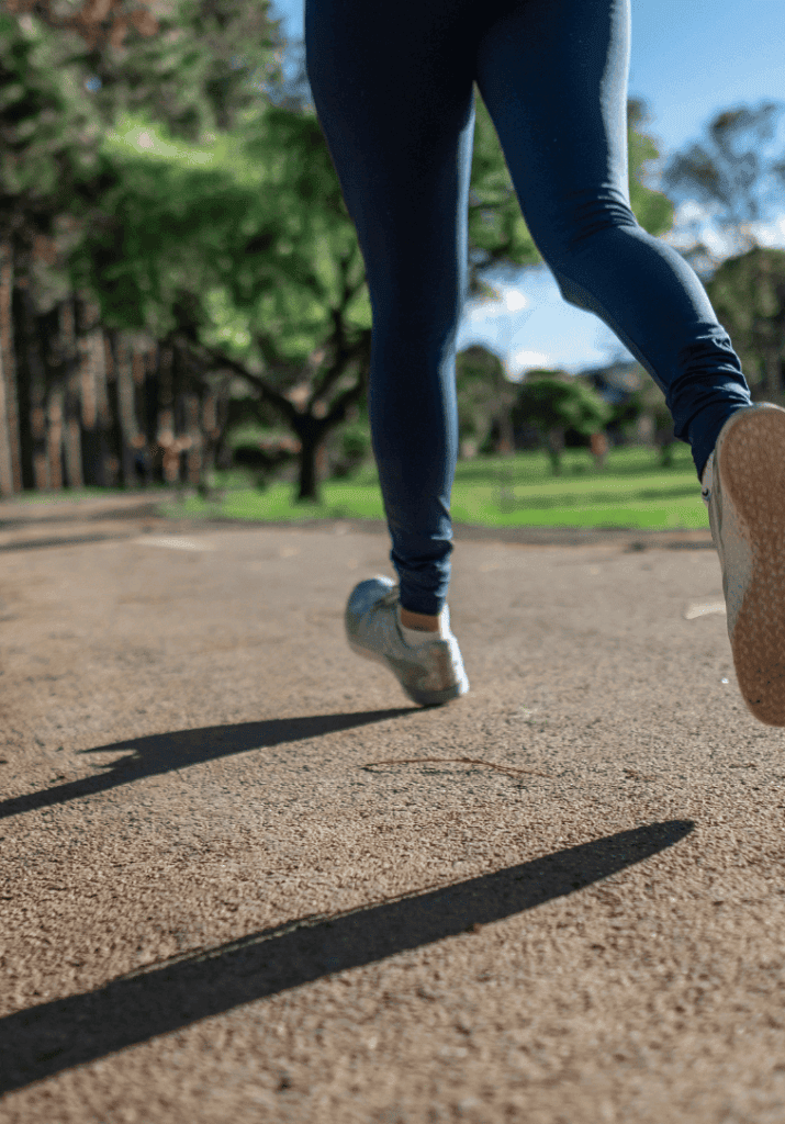 a beginner runner, running outside at a park