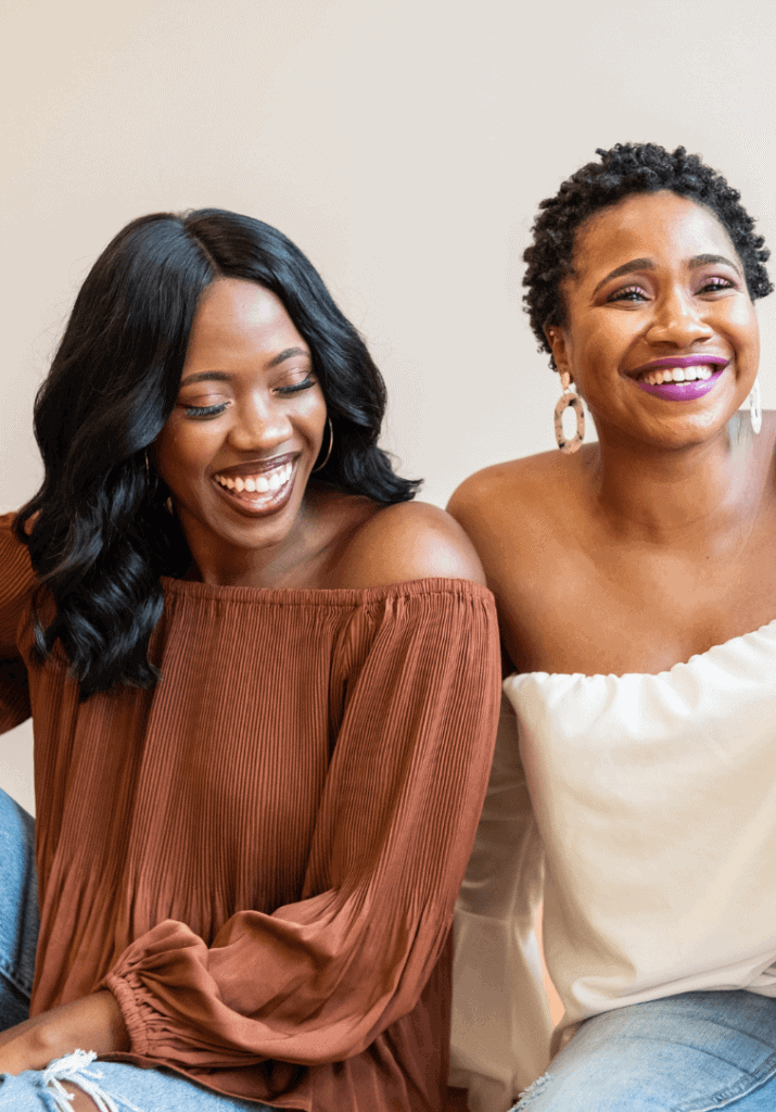 two black women laughing and enjoying life, which shows how pretty privilege and body size can affect a person's life. 