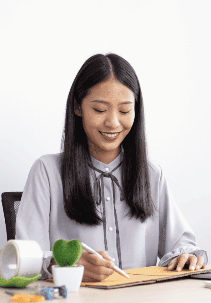 An Asian woman writing and being productive. 