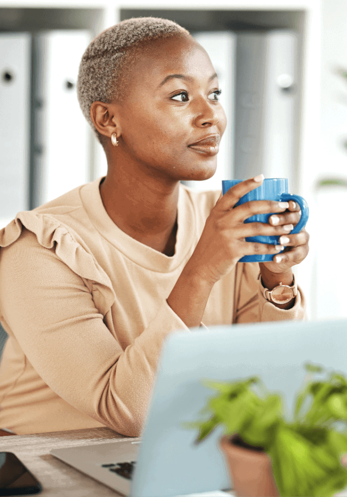 a woman drinking out of a mug and pondering effective task prioritization techniques