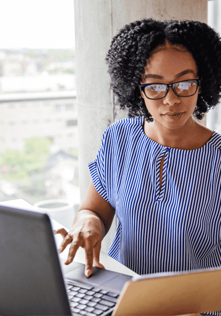 a woman with a curly twist out working on her laptop looking for Work-Life Balance Tips for Women Who Want to Thrive