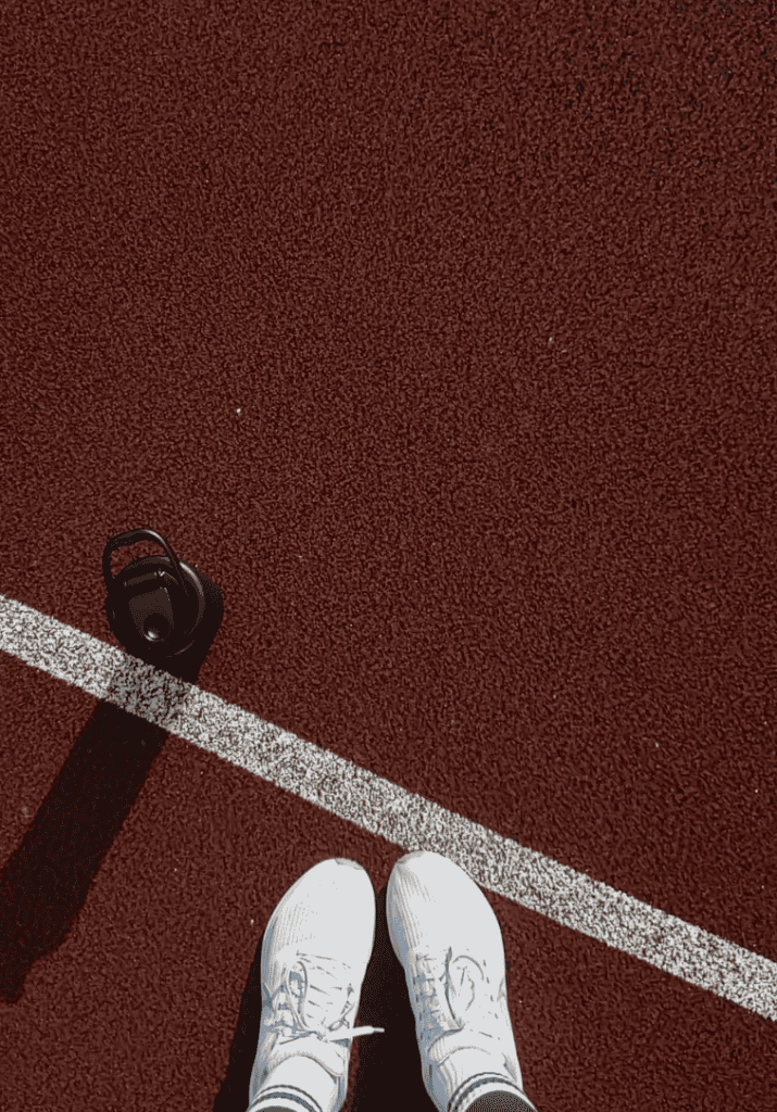 an image of someone on a track with white sneakers and a water bottle