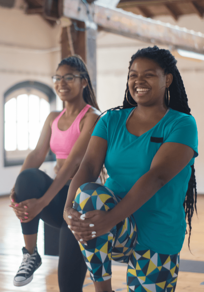women holding their knees to their chest, working out.