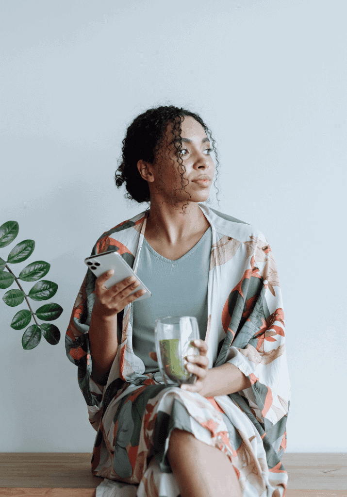 a woman looking over her shoulder holding a green drink