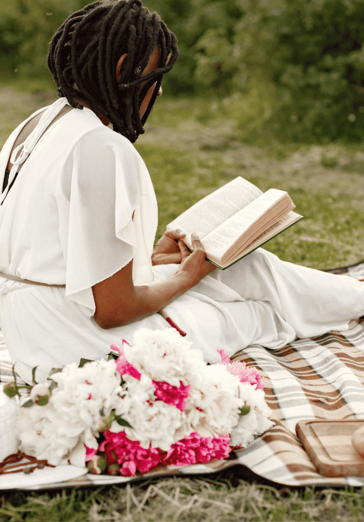 black woman reading a non fiction book to level up her life.