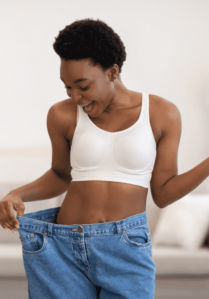  a woman trying on jeans excited about her weightloss.