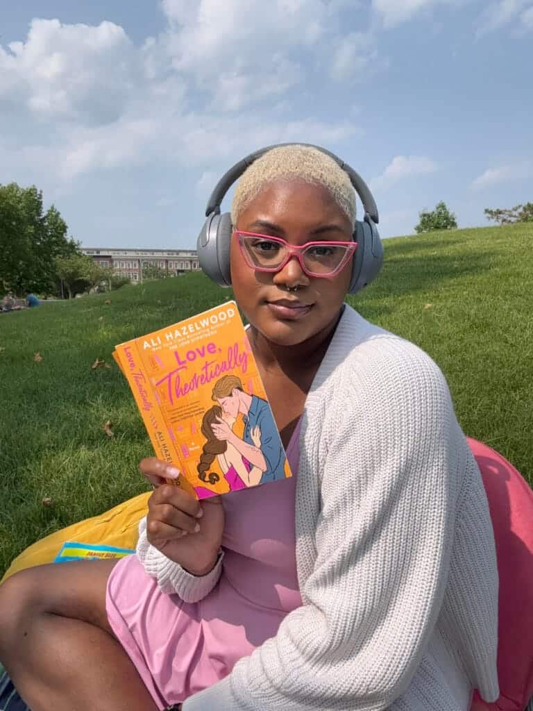 black girl on her reader journey with a book by ali hazelwood