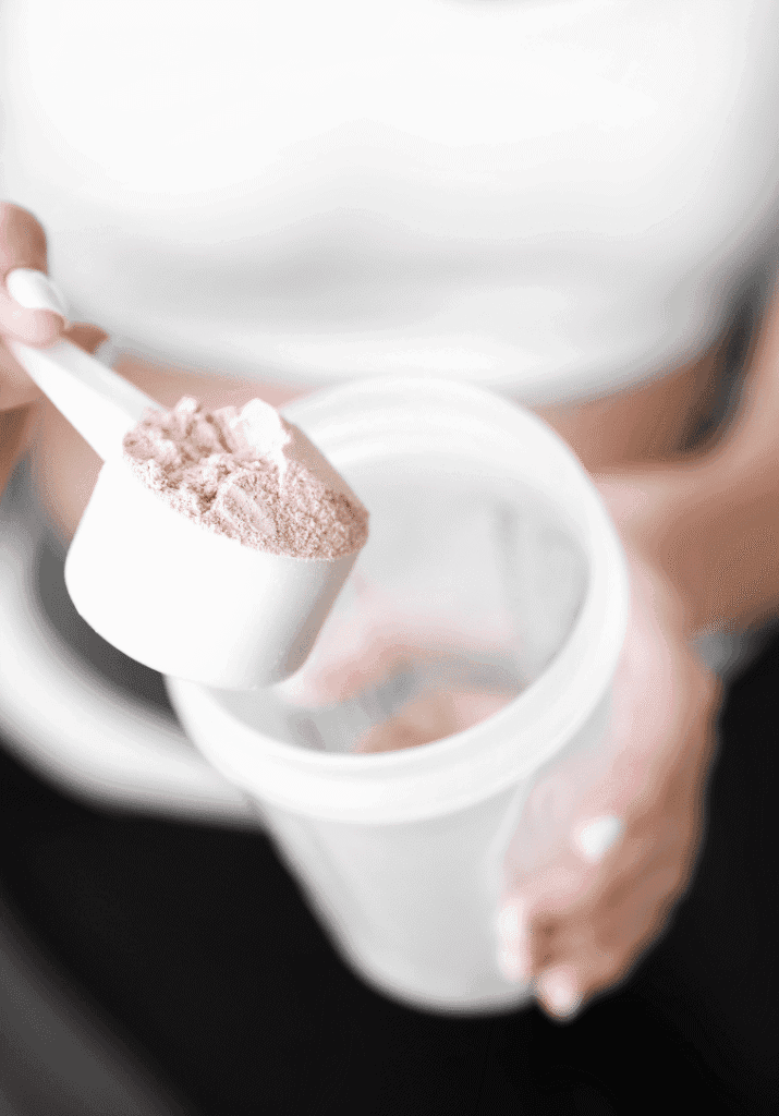 a woman scooping protein powder