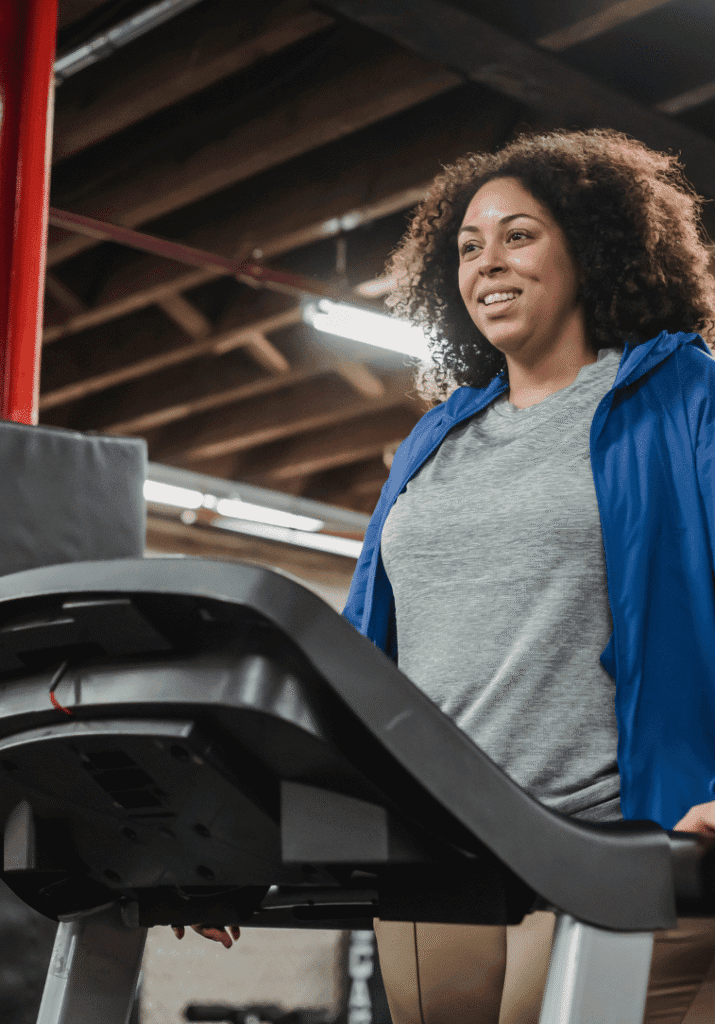 a plus size woman at the gym walking on the treadmill