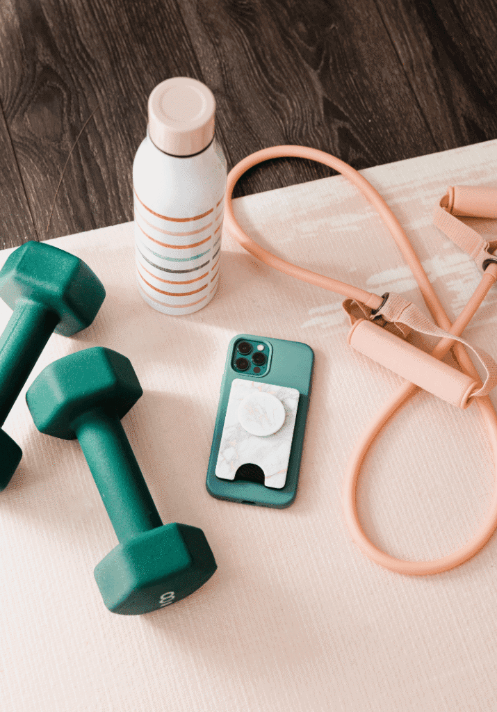 a picture of some items that are women gym essentials; including barbell, ropes, cell phone