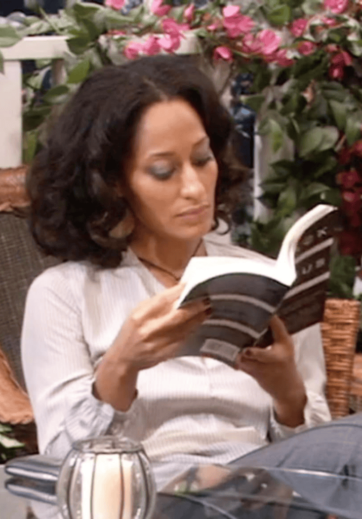 Woman reading a book while sitting in a chair, slow burn romance reading moment