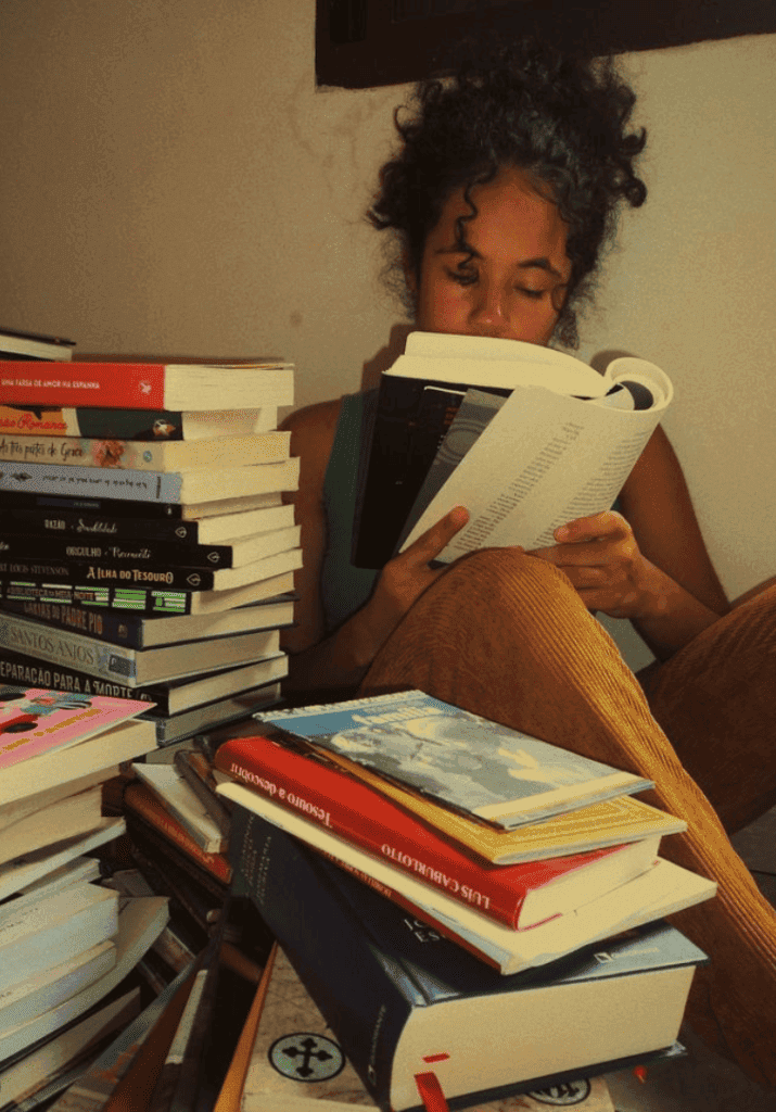 Woman with a large stack of books for a reading lifestyle blog