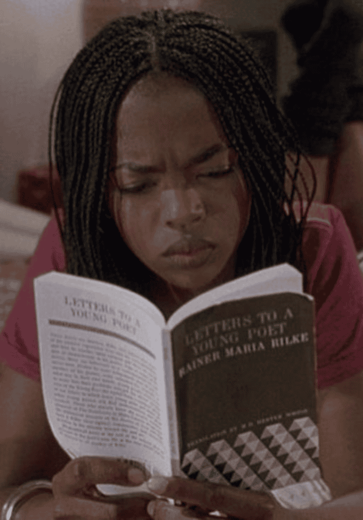 a woman reading a book on her bed